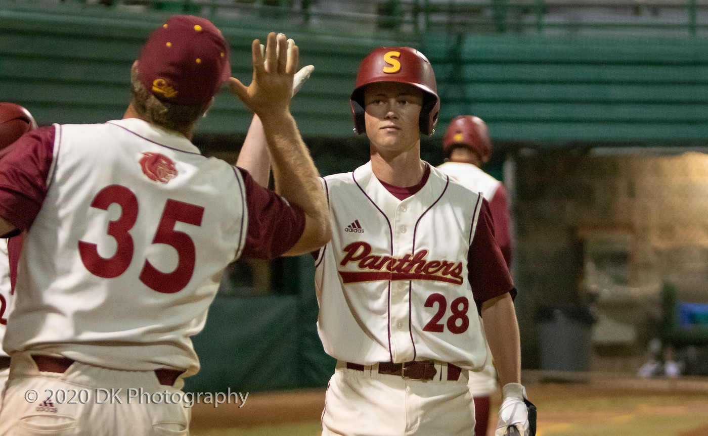 City College's Greg Nichols (#28) gets a high five from teammate Nick Cirelli (#35) after scoring a run in the game against De Anza College at Union Stadium on Feb. 21st.