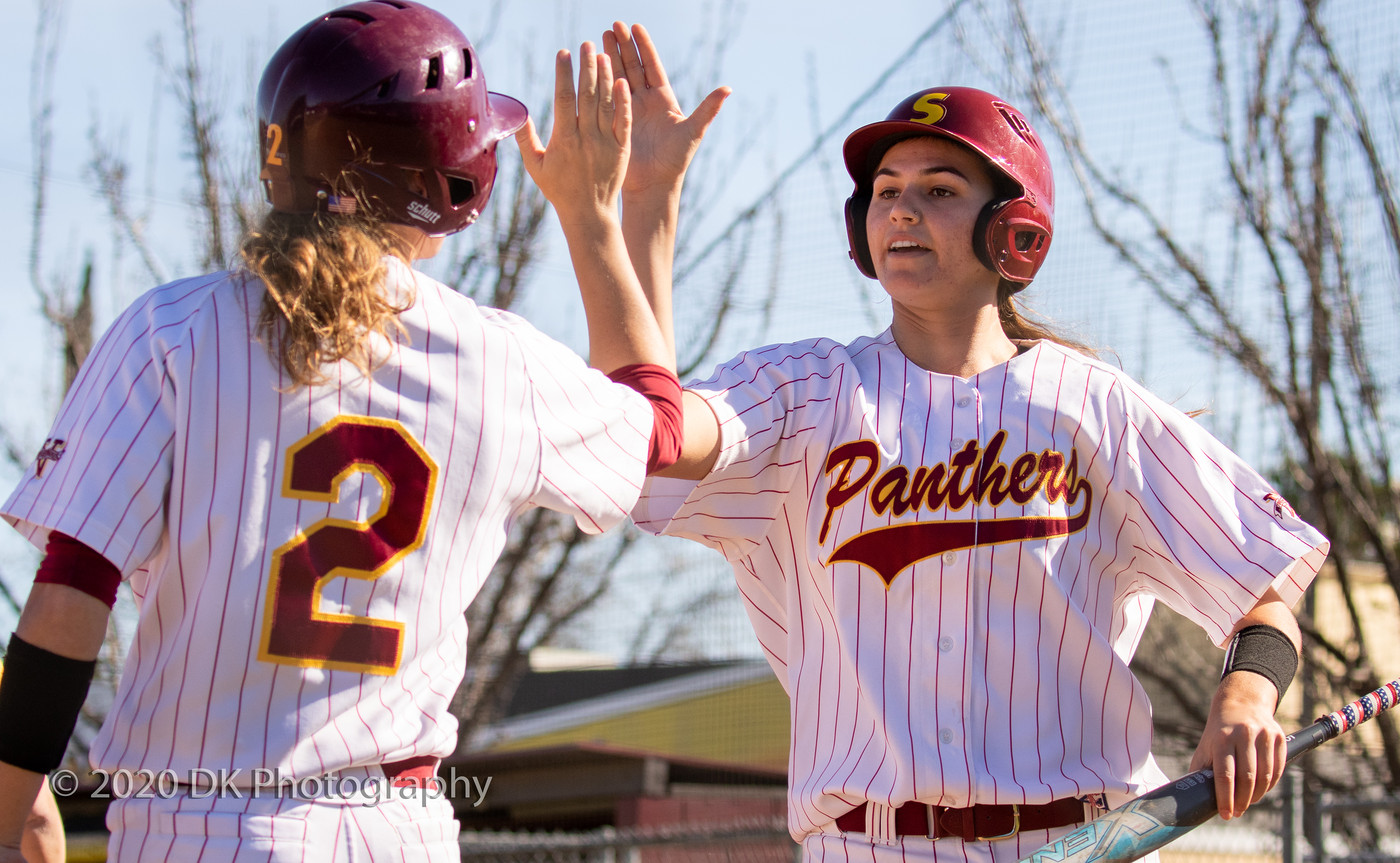 Elisa Cueva (right), City College freshman high fives with Rylee Retzer after scoring a run in the first game of a double header against Merced College at The Yard on Feb. 11th. 